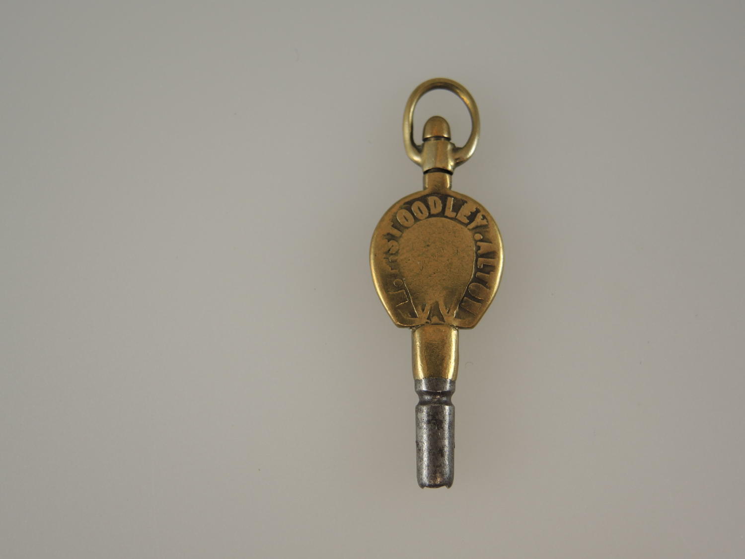 Gilt metal Horse shoe shaped advertising pocket key. c1890