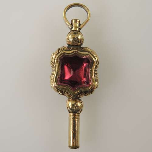 Victorian gilt cased pocket watch key set with a pink glass stone and agate c1850
